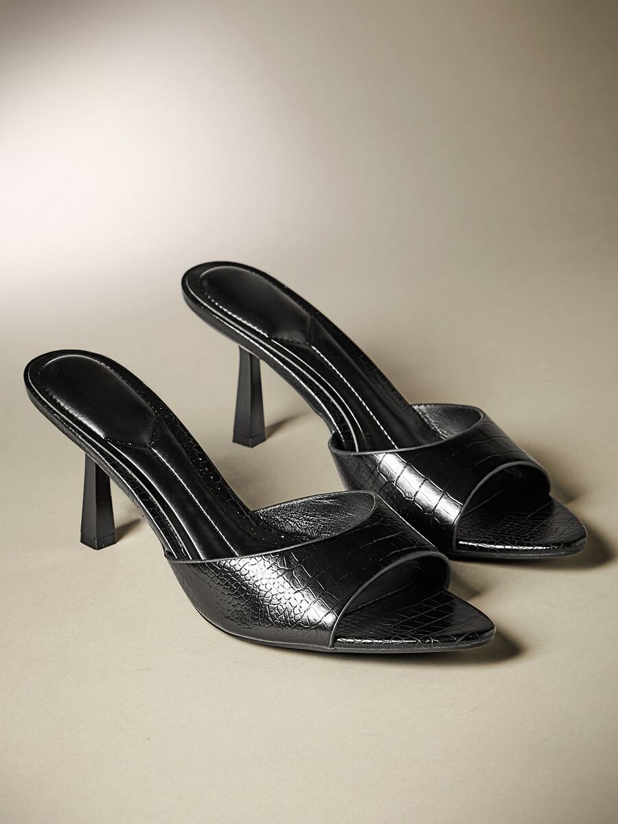 Pair of women's minimalist black pointy toe stiletto heel sandals with slingback straps.
