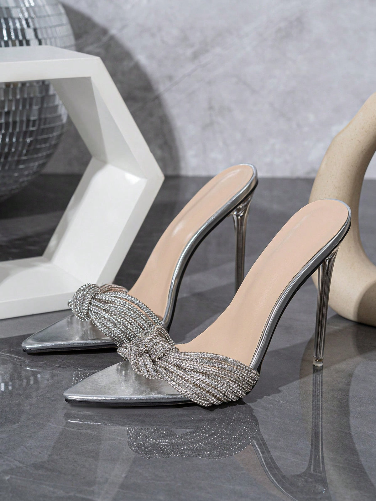 Silver high heel sandals featuring open toe design, stiletto heel, sparkling rhinestone details, and wrap-around tie-up ankle straps.