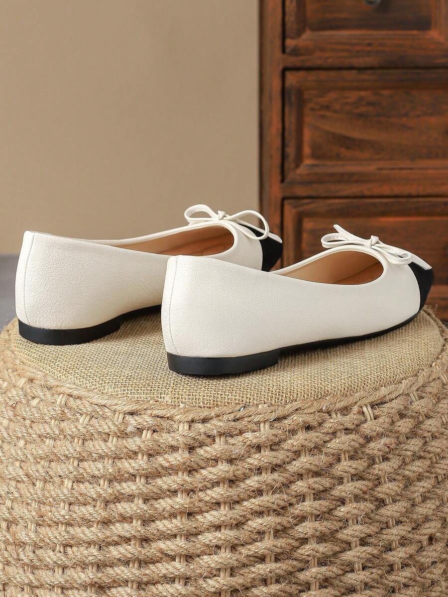 Pair of women's square toe slip-on flat shoes featuring a delicate bow detail and low vamp design.
