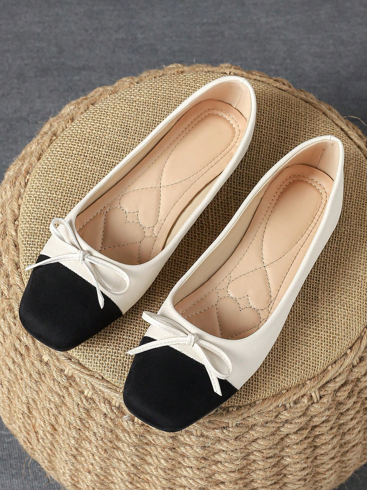 Pair of women's square toe slip-on flat shoes featuring a delicate bow detail and low vamp design.