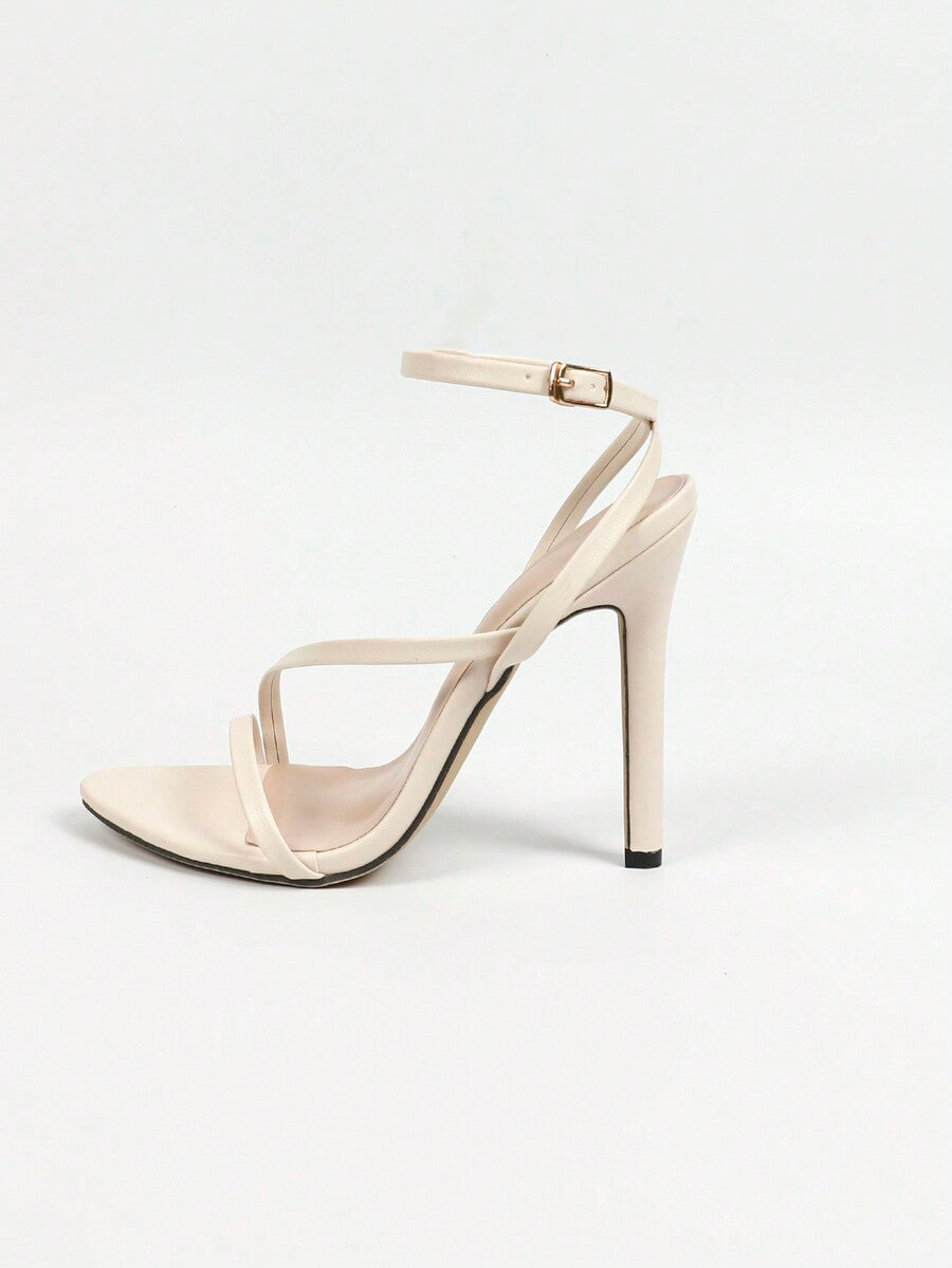 Glossy high heel sandals with open round toe, stiletto heel, and cross ankle buckle strap