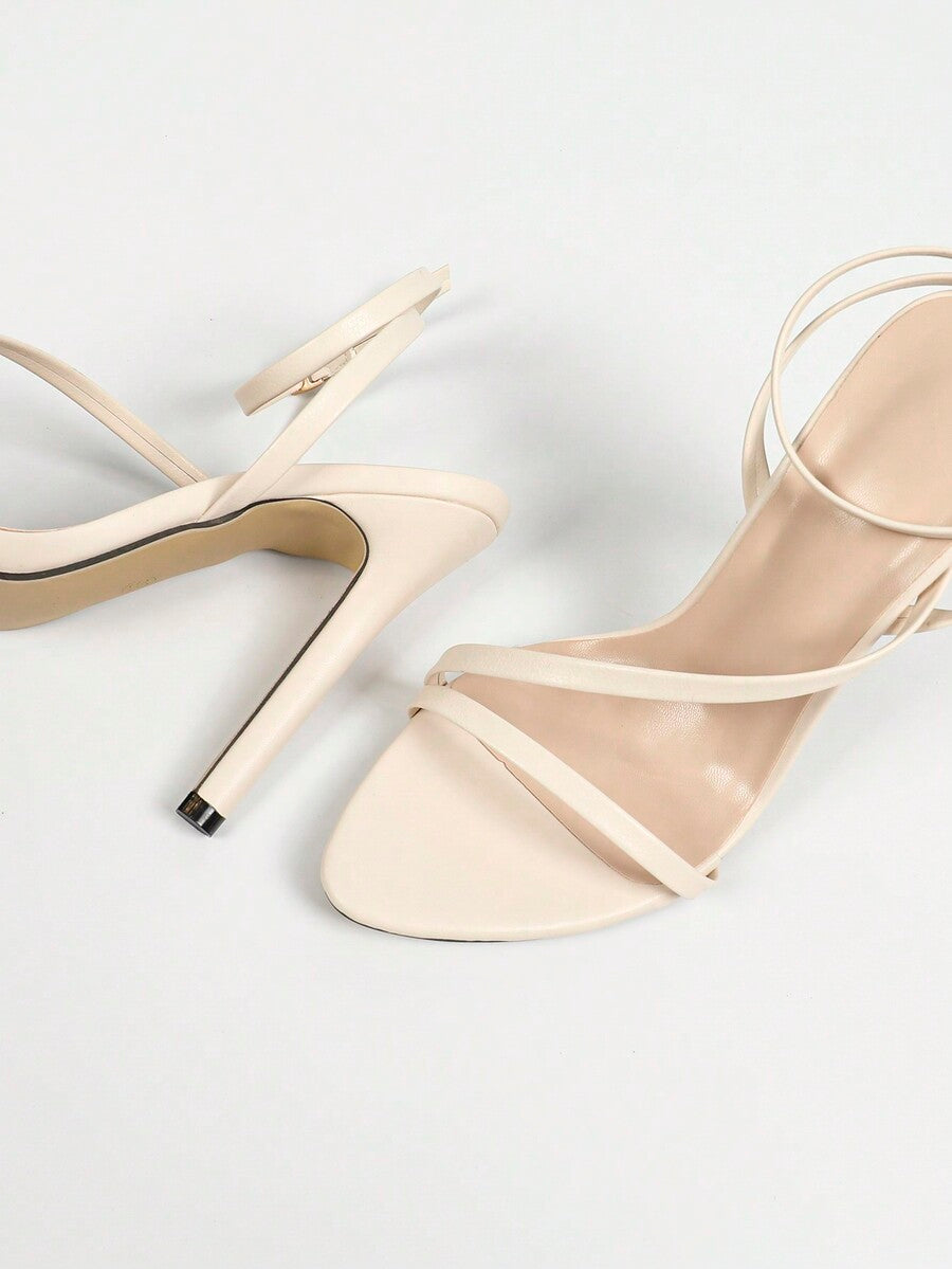 Glossy high heel sandals with open round toe, stiletto heel, and cross ankle buckle strap