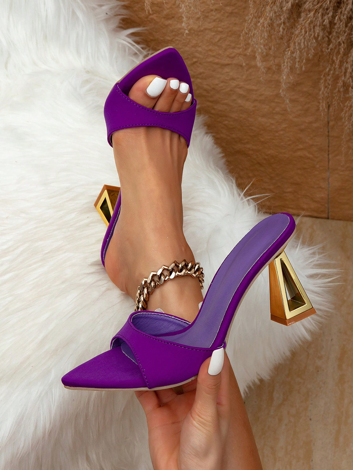 Women's pointed toe high heel sandals in silver with sculptural mid heels and a slip-on design for party wear.
