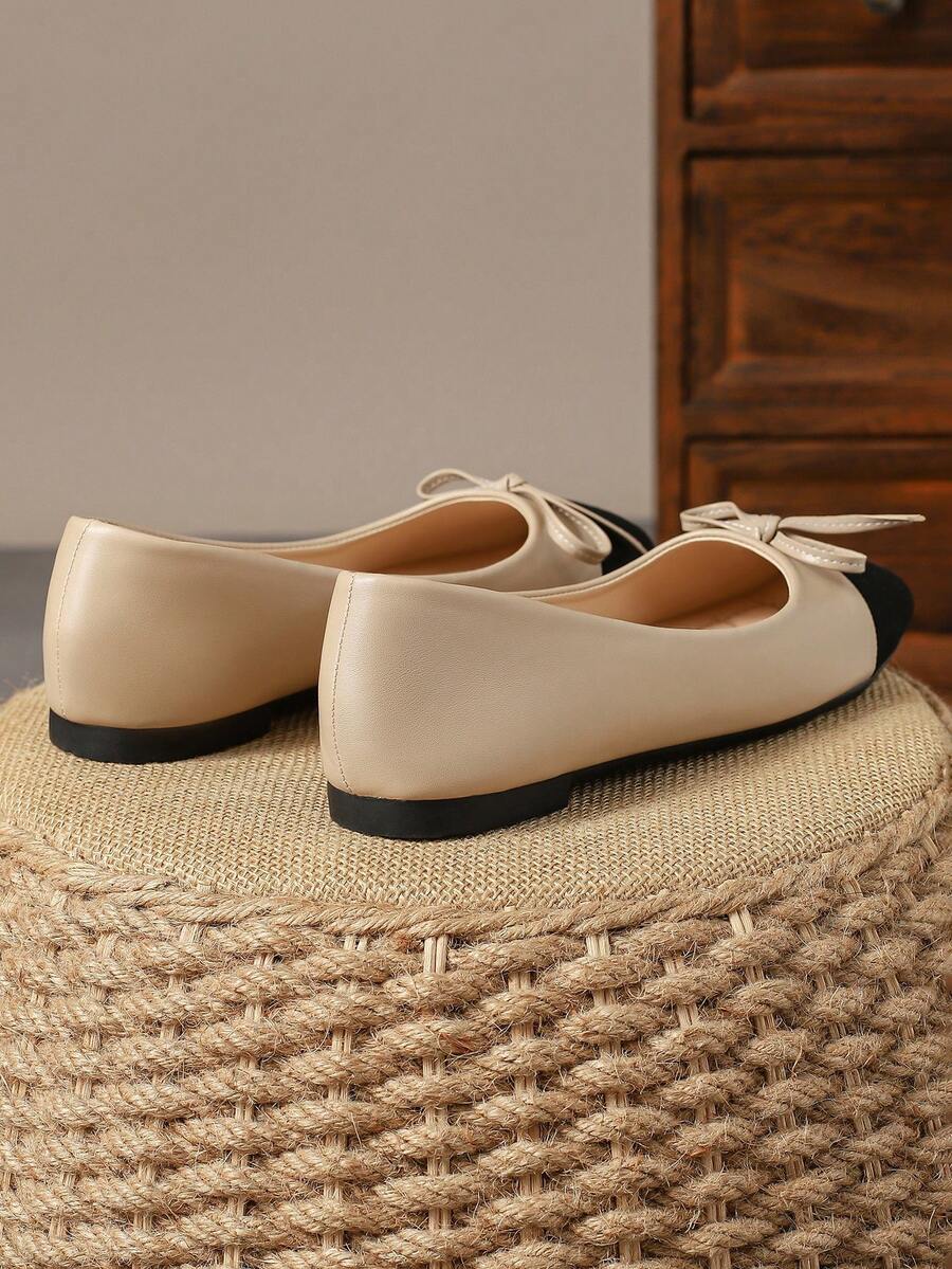 Pair of women's square toe slip-on flat shoes featuring a delicate bow detail and low vamp design.