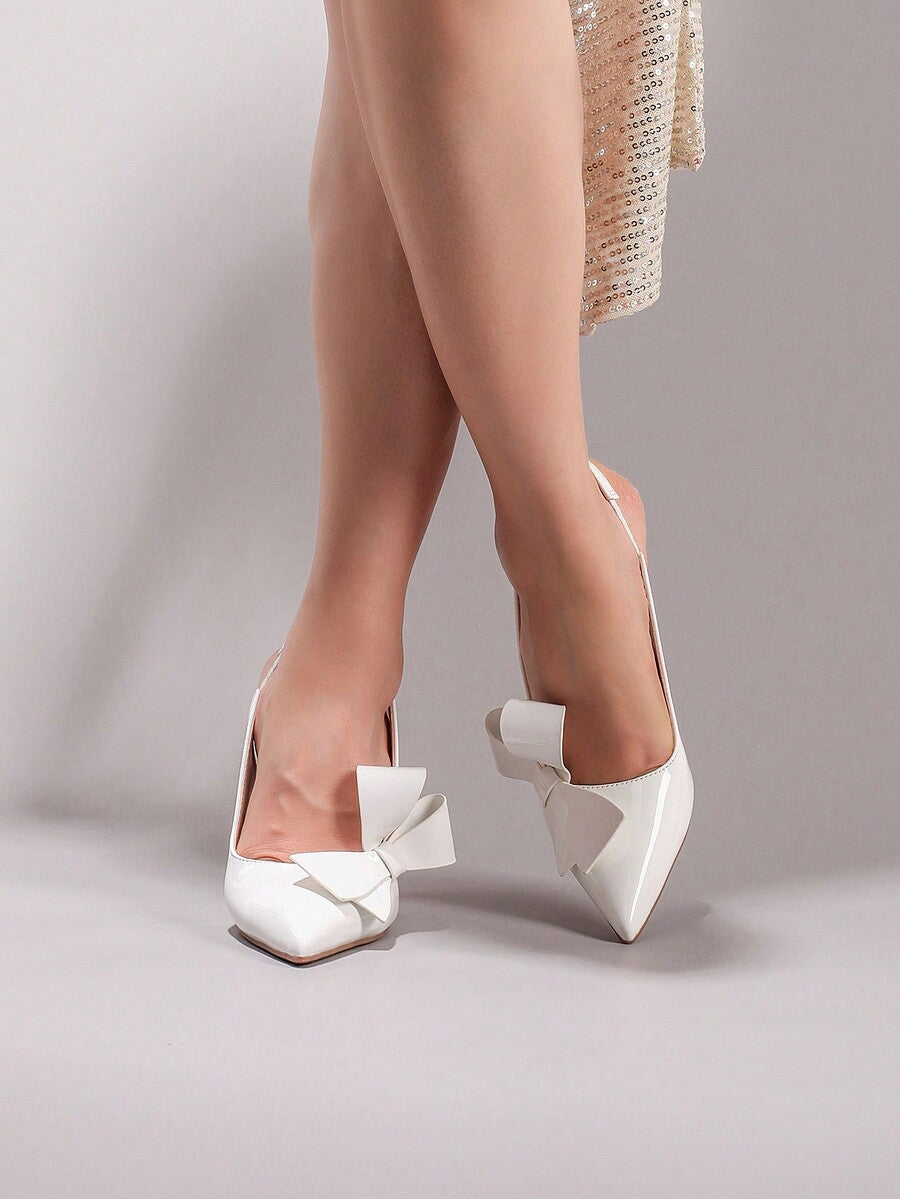 Black lace pointed toe high heel pumps featuring stiletto heels and a decorative bow accent.
