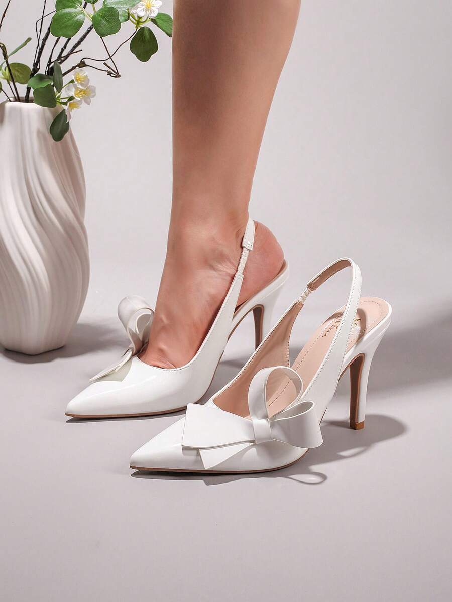 Black lace pointed toe high heel pumps featuring stiletto heels and a decorative bow accent.