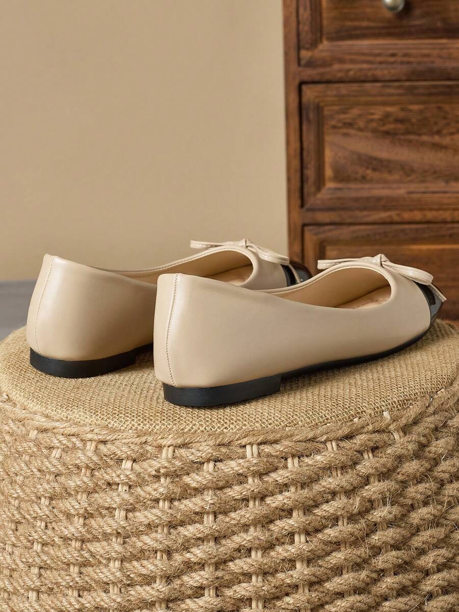 Pair of women's square toe slip-on flat shoes featuring a delicate bow detail and low vamp design.