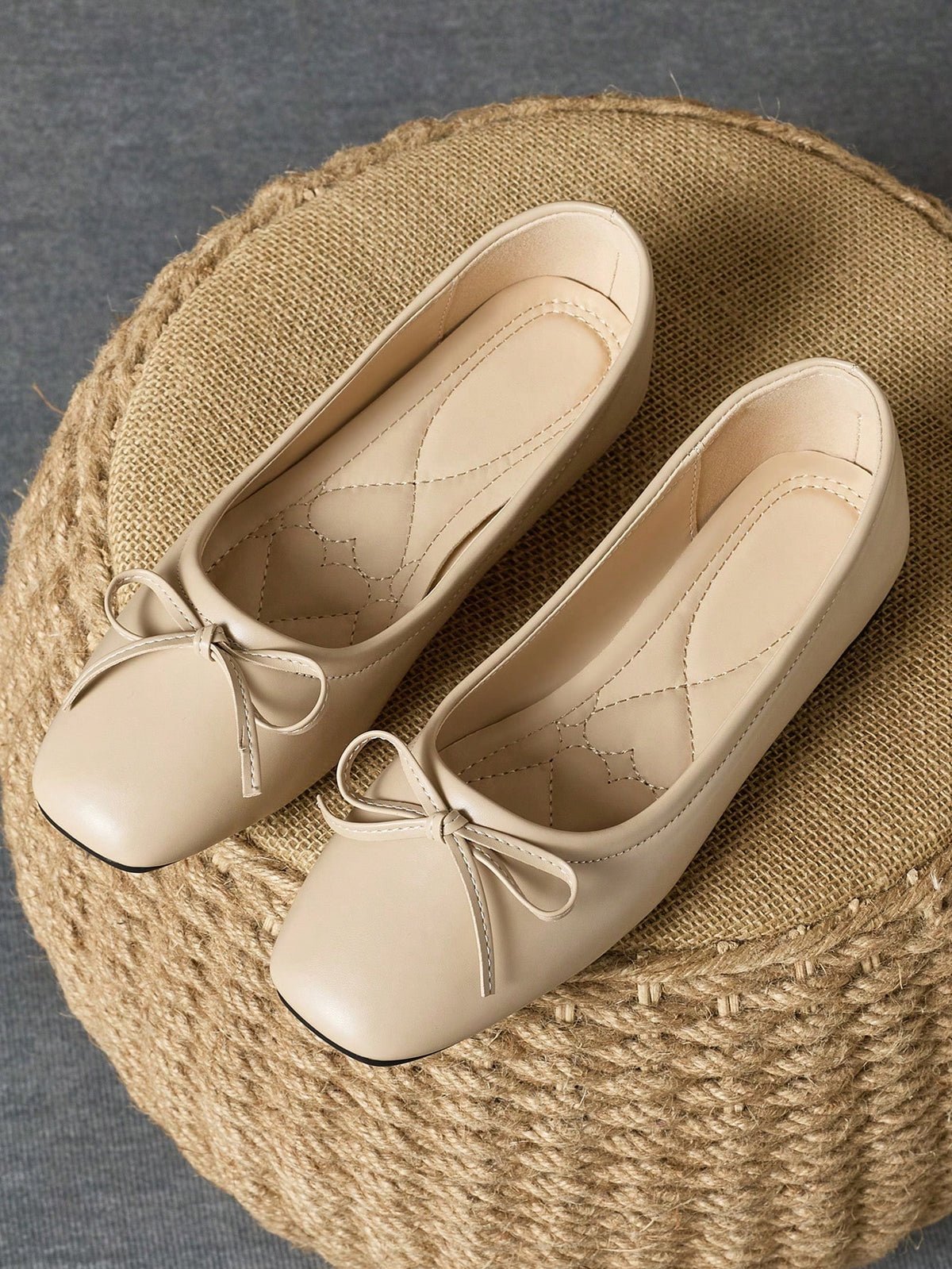 Pair of women's square toe slip-on flat shoes featuring a delicate bow detail and low vamp design.
