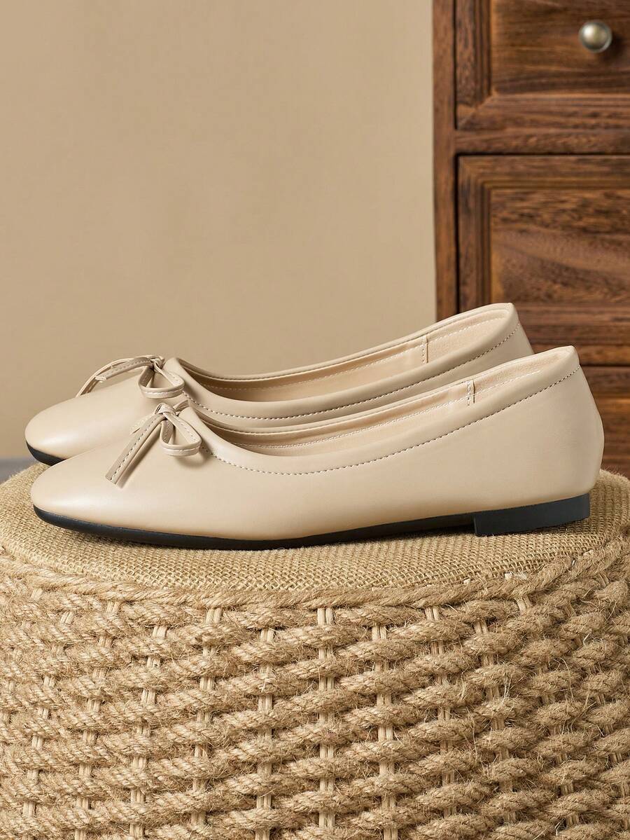 Pair of women's square toe slip-on flat shoes featuring a delicate bow detail and low vamp design.