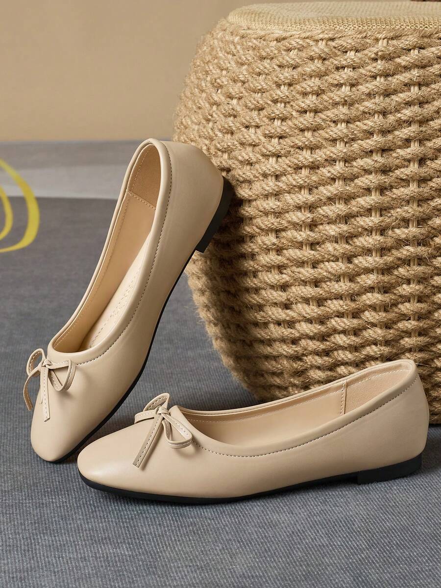 Pair of women's square toe slip-on flat shoes featuring a delicate bow detail and low vamp design.