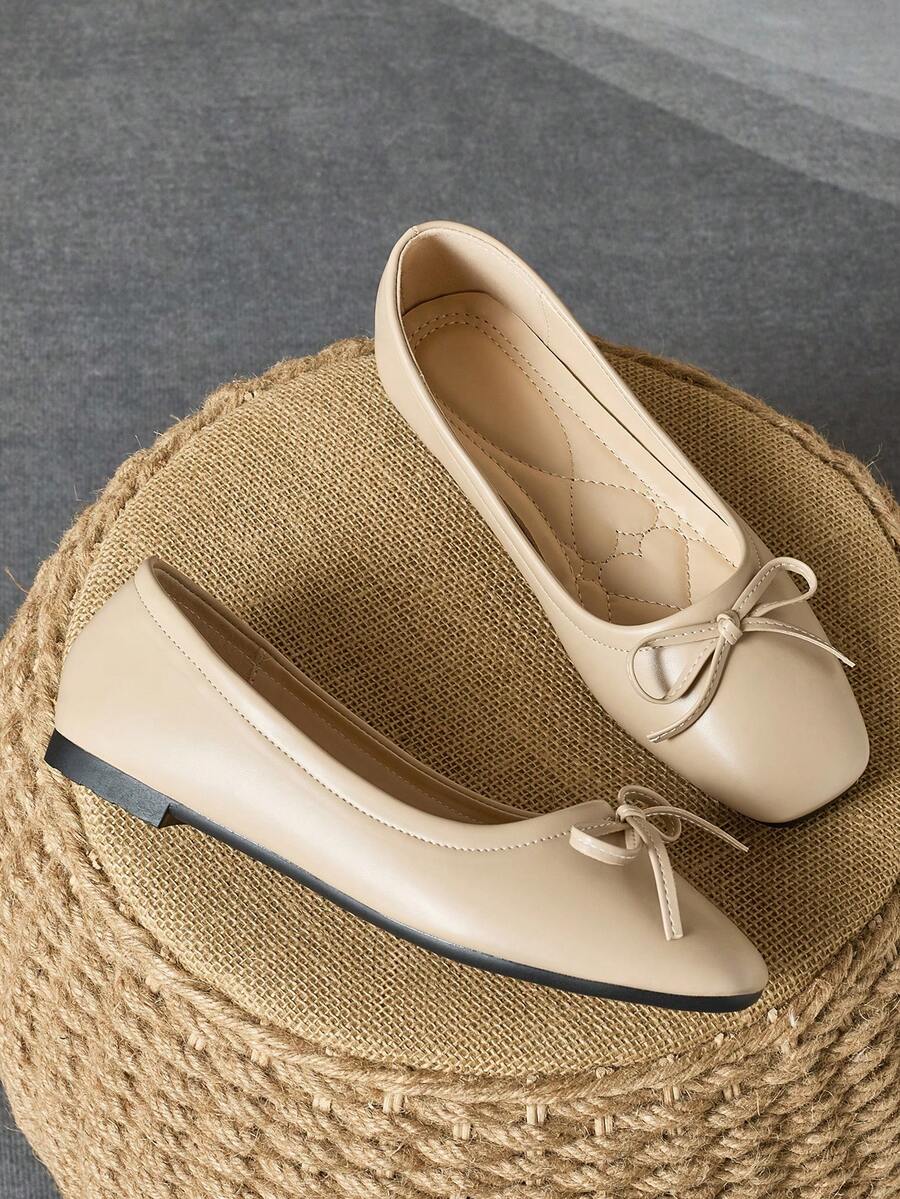 Pair of women's square toe slip-on flat shoes featuring a delicate bow detail and low vamp design.