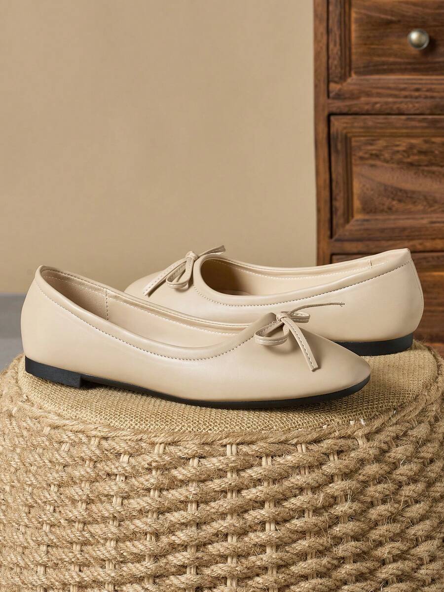 Pair of women's square toe slip-on flat shoes featuring a delicate bow detail and low vamp design.