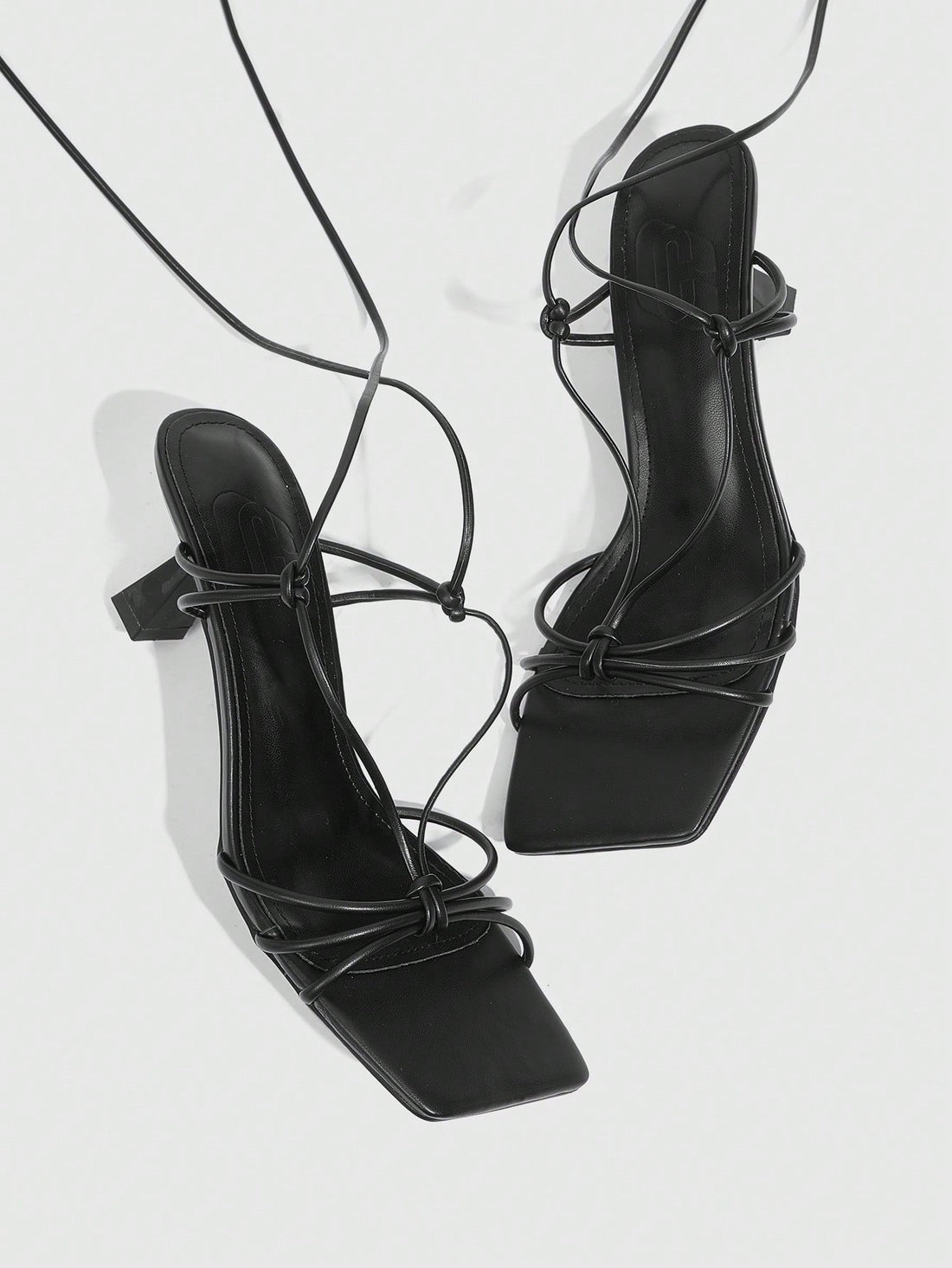 Women's square toe stiletto heel slingback sandals featuring sleek straps and buckle closure in a backless design.