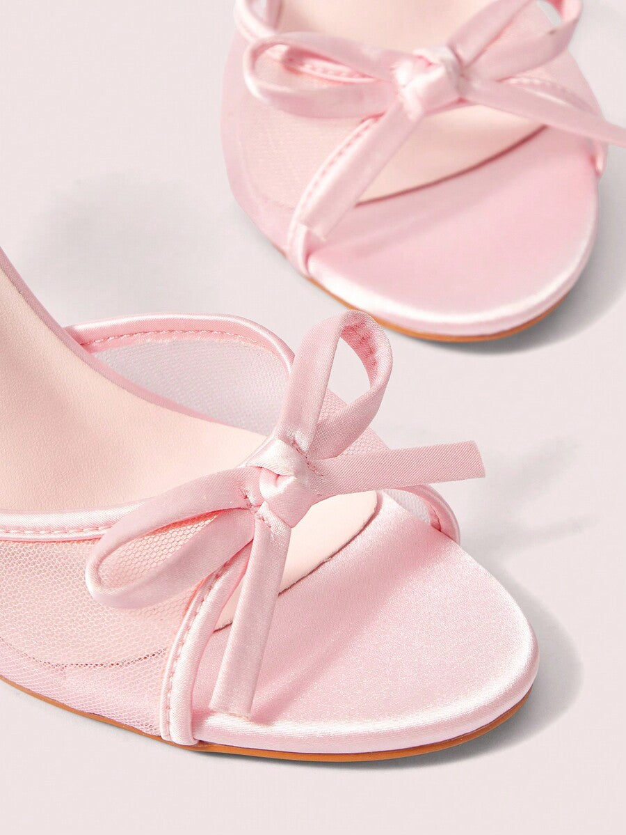 Pair of women's open toe stiletto heeled sandals crafted in satin with a bow accent