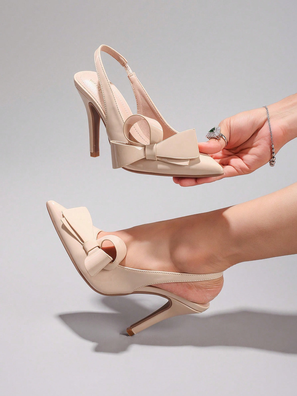 Black lace pointed toe high heel pumps featuring stiletto heels and a decorative bow accent.