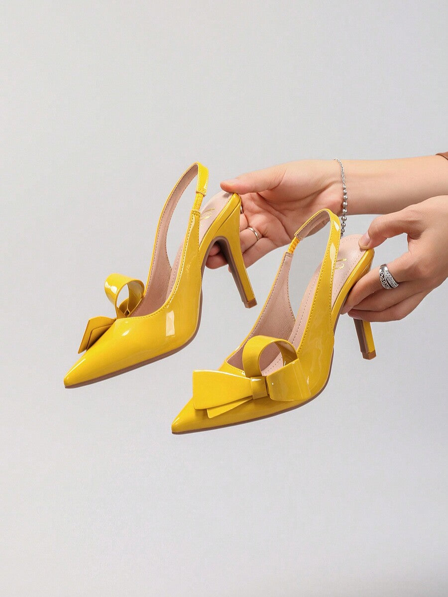 Black lace pointed toe high heel pumps featuring stiletto heels and a decorative bow accent.