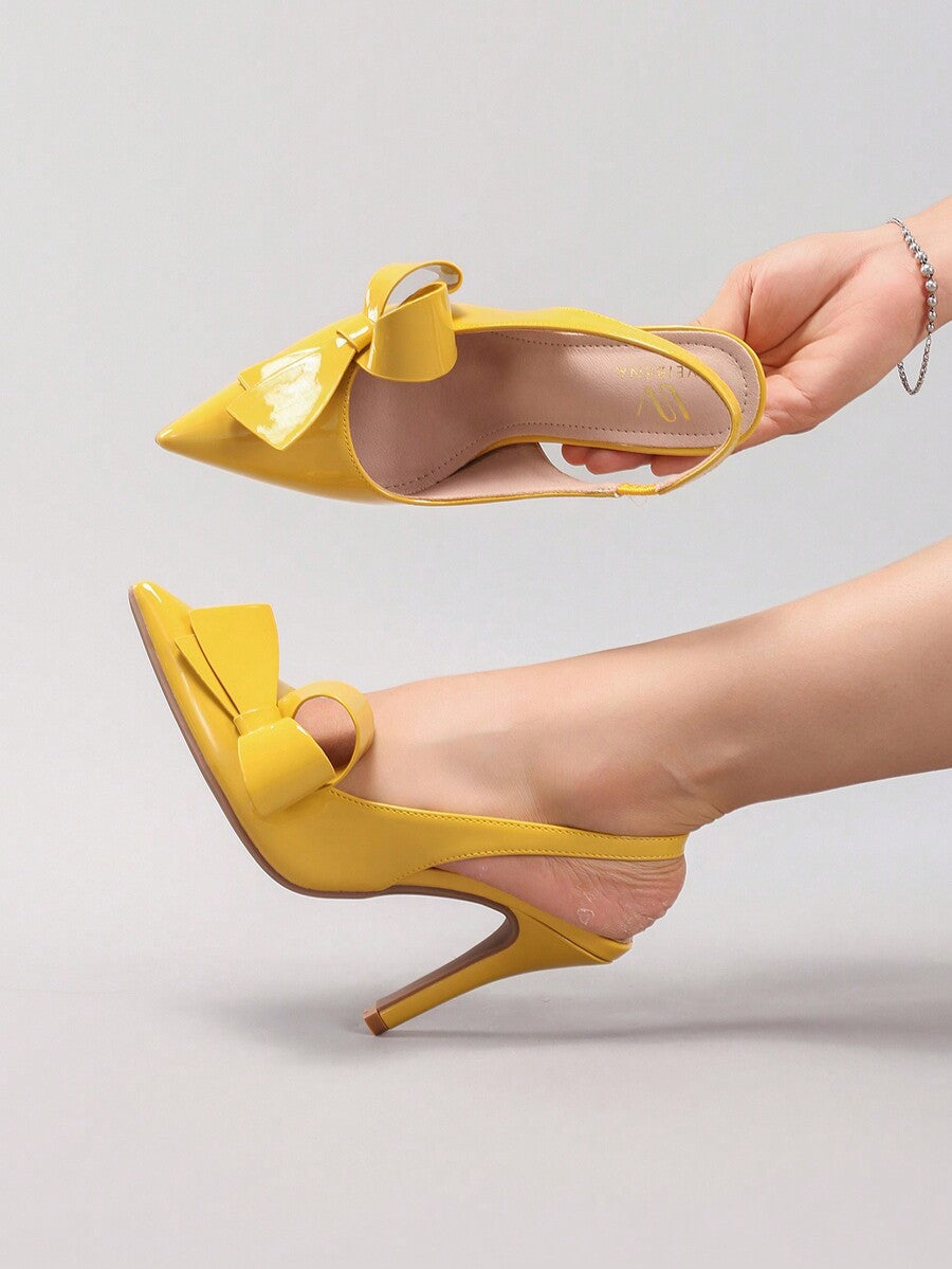 Black lace pointed toe high heel pumps featuring stiletto heels and a decorative bow accent.