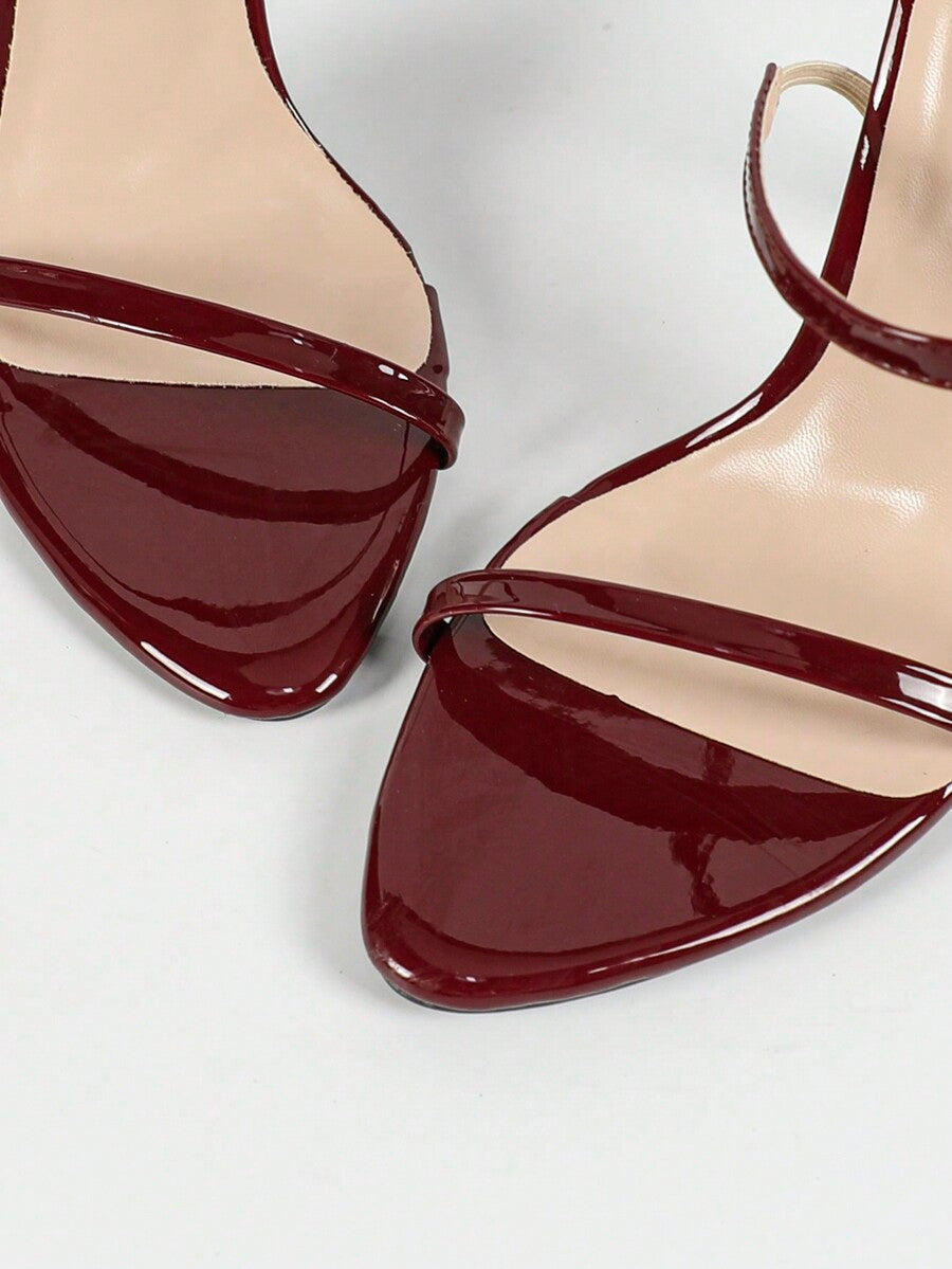 Women's stiletto high heel sandals with round open toe and back ankle strap in solid finish.