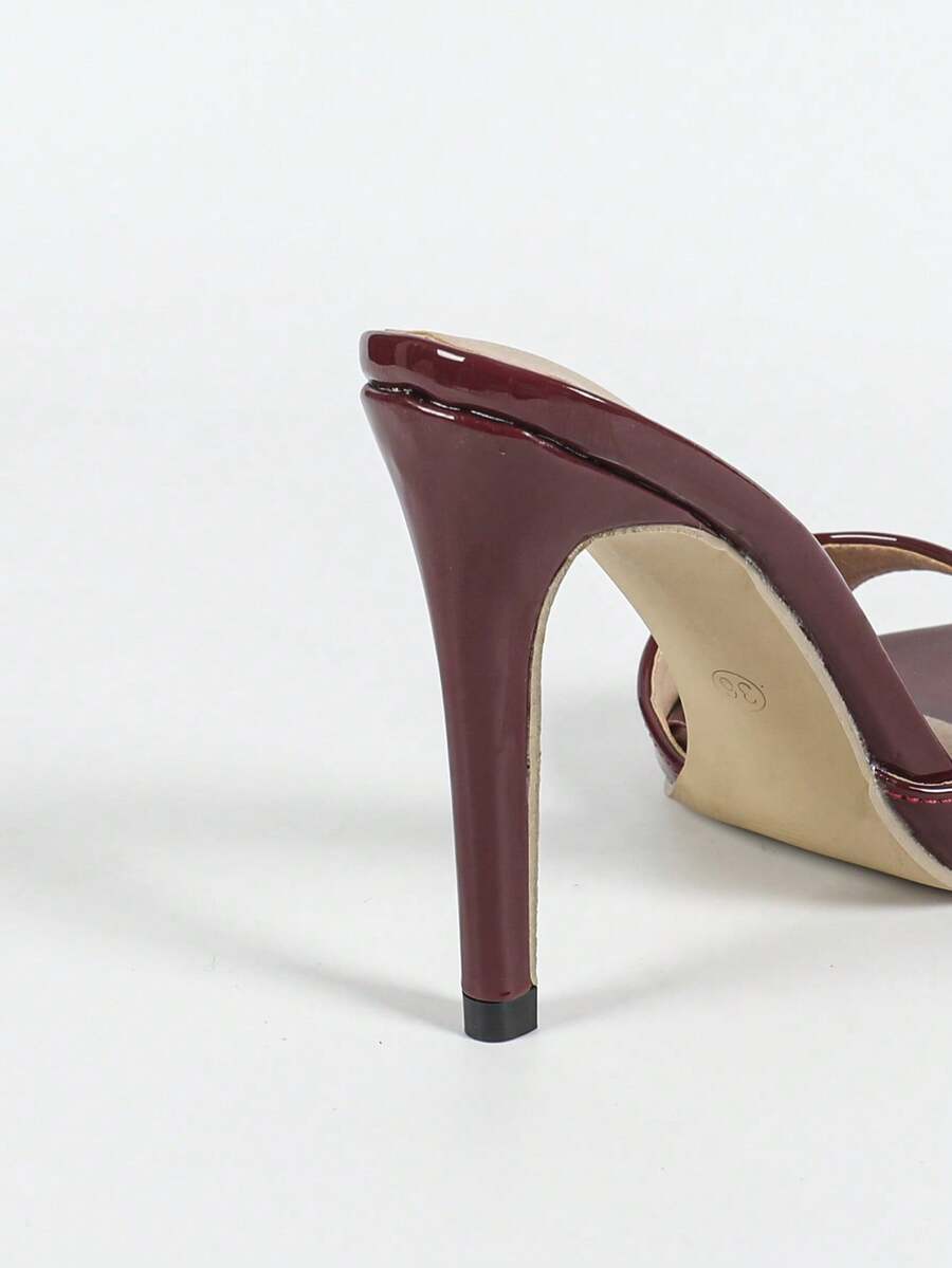 Women's black patent strap pointed toe high heel sandals featuring a stiletto heel and open hollow-out slingback design.