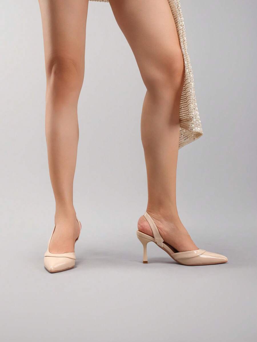 Pair of women's white pointed-toe kitten heel pumps with slingback straps and sleek patent finish