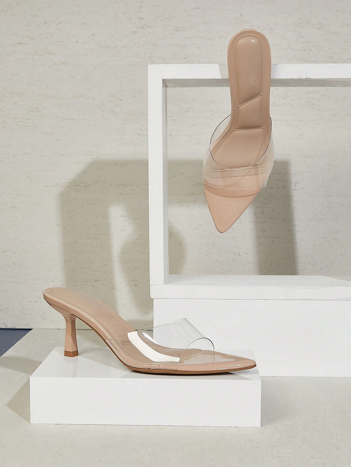 Black pointy toe kitten heel shoes for women featuring a sleek cut out mule design and glossy patent leather finish.
