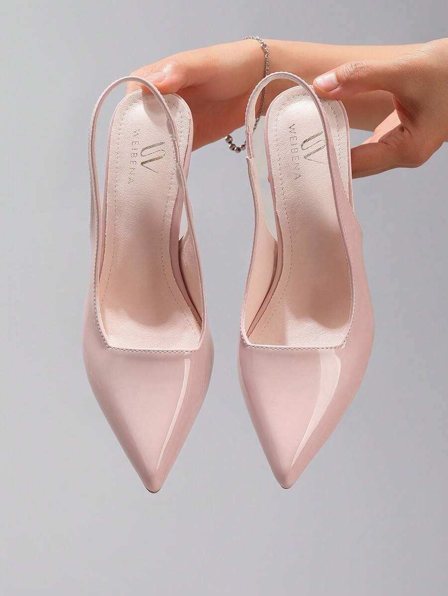 Pair of women's white pointed-toe kitten heel pumps with slingback straps and sleek patent finish