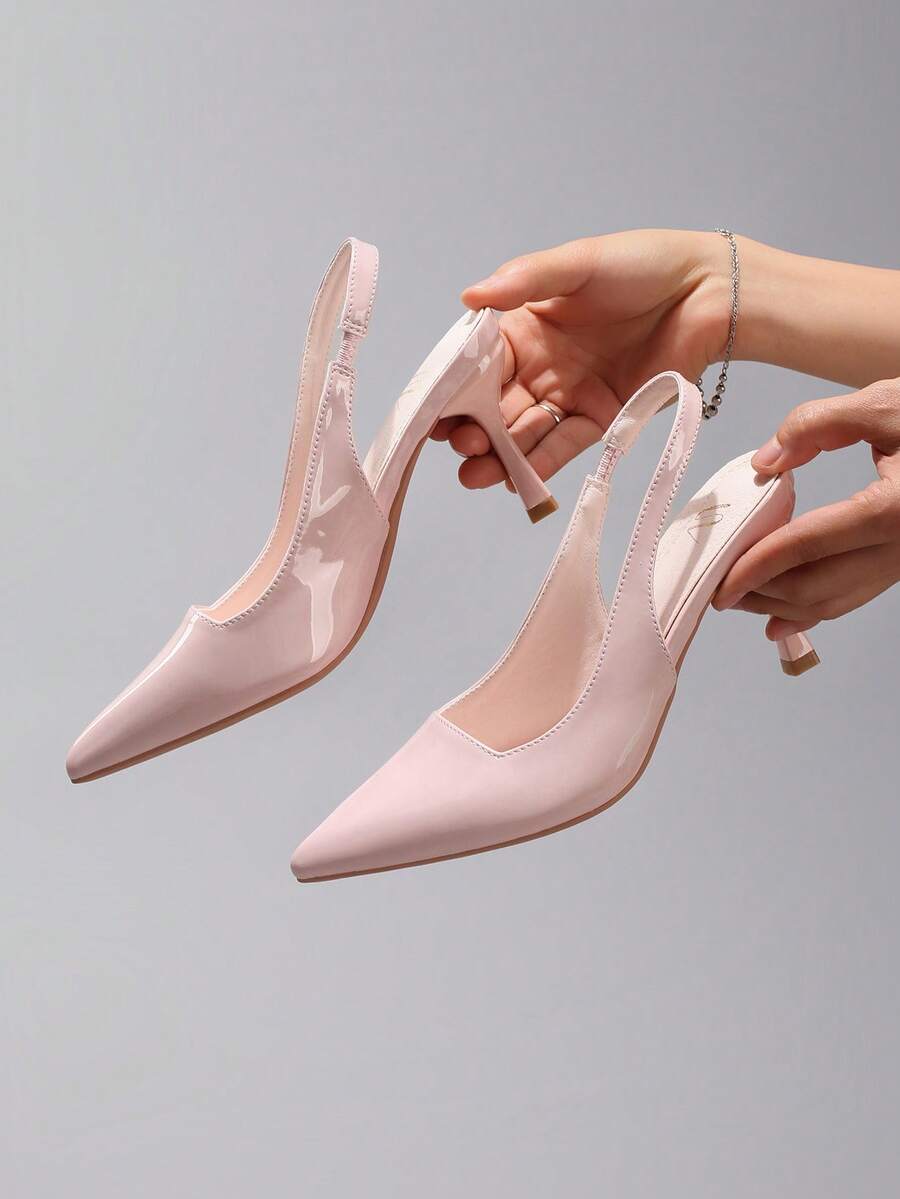 Pair of women's white pointed-toe kitten heel pumps with slingback straps and sleek patent finish