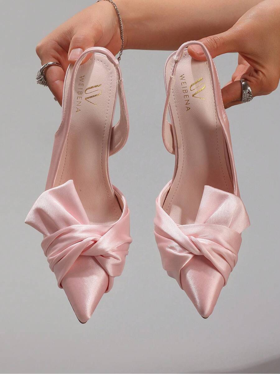 Lace embroidered high heels with thin stiletto heel, pointed toe, rhinestone embellishments, and ankle strap buckle closure.