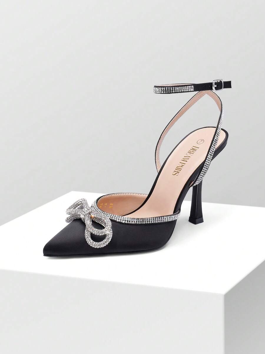 Women's rhinestone ankle strap high heels with pointed closed toe, strappy bow details, and stiletto heel for wedding and prom wear.