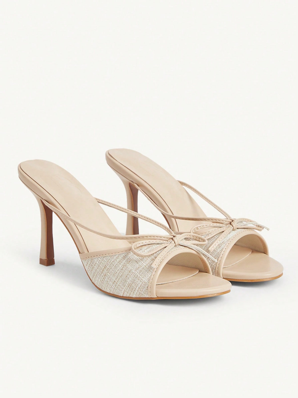Elegant high heel sandals with romantic bow strap and slim stiletto heel for party and wedding occasions.