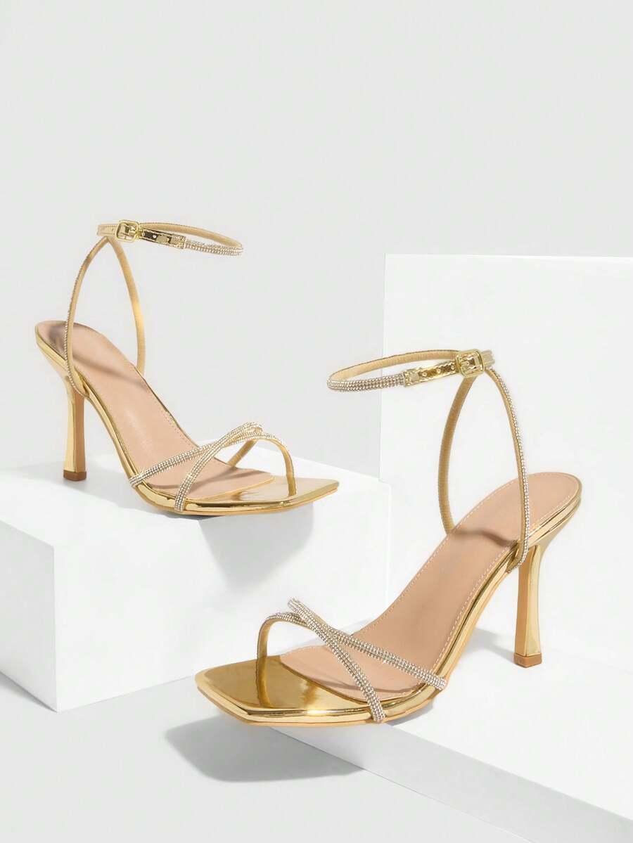 Champagne rhinestone ankle strap heeled sandals with open toe and high stiletto heel for women.