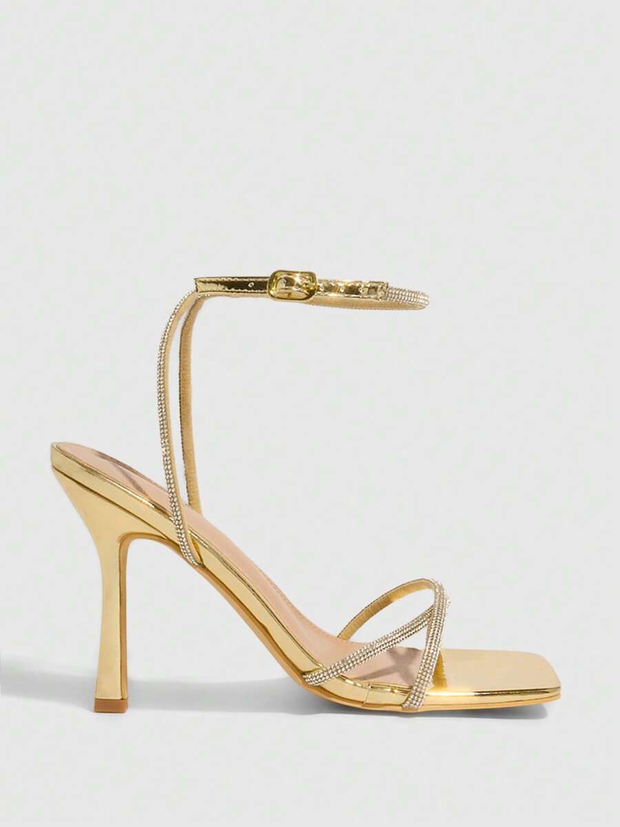 Champagne rhinestone ankle strap heeled sandals with open toe and high stiletto heel for women.