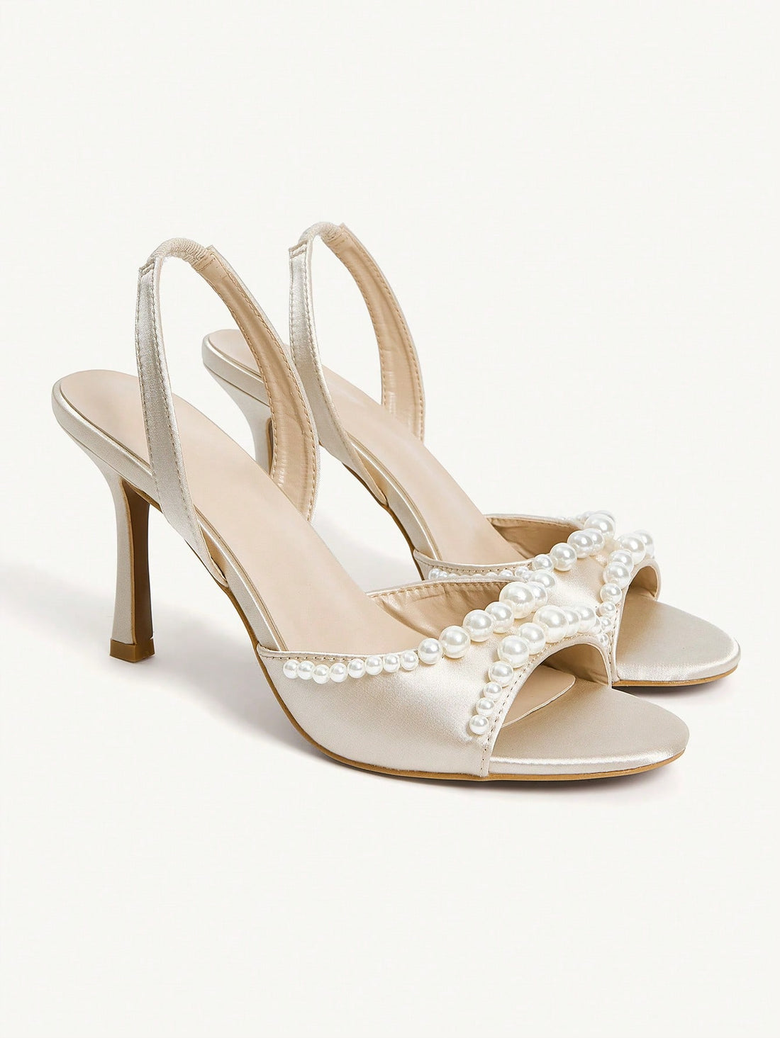 Elegant women's satin high heel sandals with pearl embellishments, stiletto heels, and slingback straps for bridal and wedding wear.