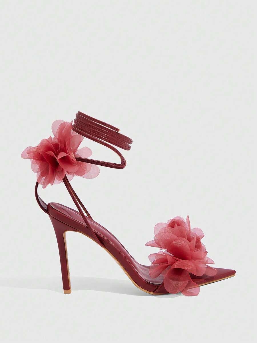 Women's open toe heeled sandals featuring 3D floral decor, satin lace-up ankle straps, and stiletto high heels.