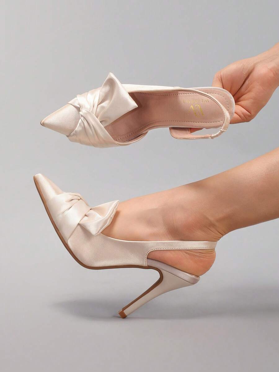 Lace embroidered high heels with thin stiletto heel, pointed toe, rhinestone embellishments, and ankle strap buckle closure.