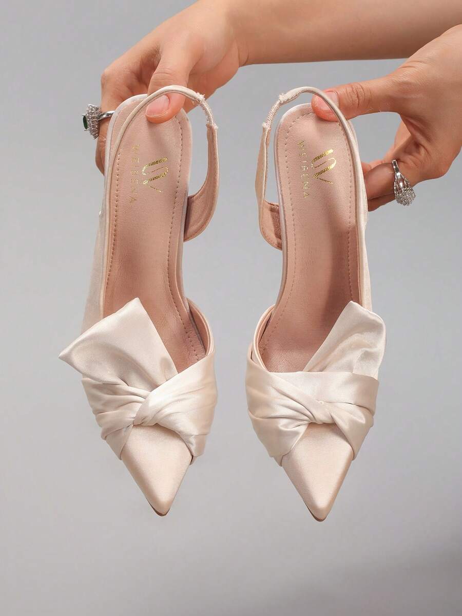 Lace embroidered high heels with thin stiletto heel, pointed toe, rhinestone embellishments, and ankle strap buckle closure.
