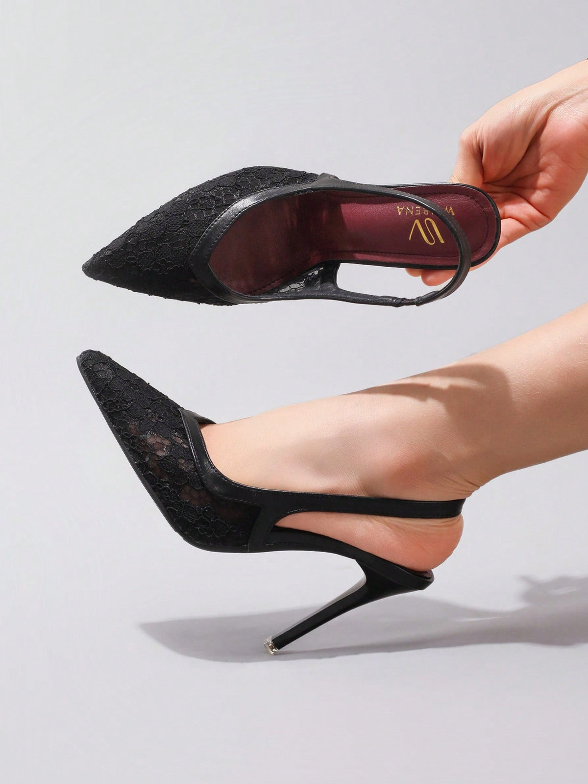 Black lace pointed toe high heel pumps featuring stiletto heels and a decorative bow accent.