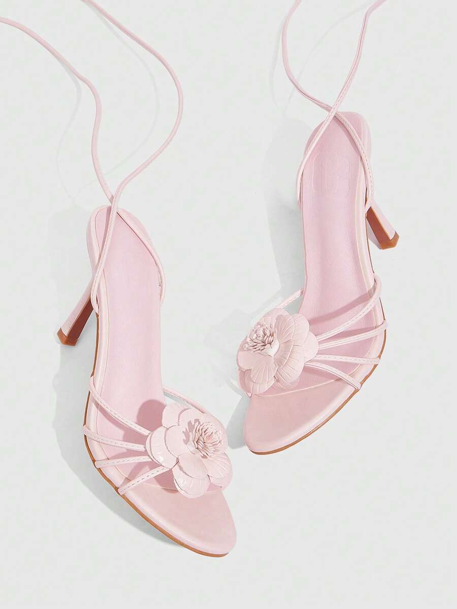 Women's round toe high heel sandals with brown flannel finish, floral trim detail, and strappy lace-up stiletto design.