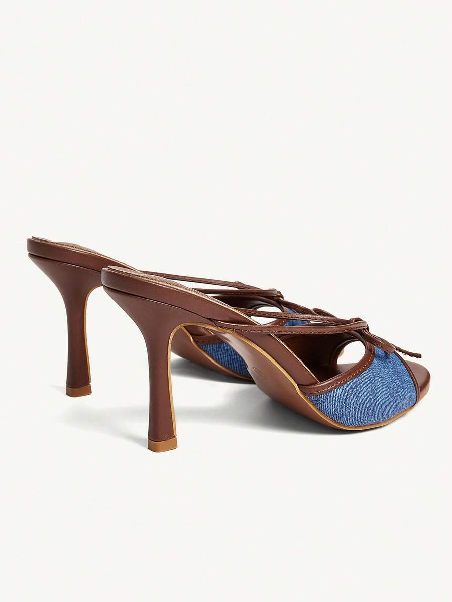 Elegant high heel sandals with romantic bow strap and slim stiletto heel for party and wedding occasions.