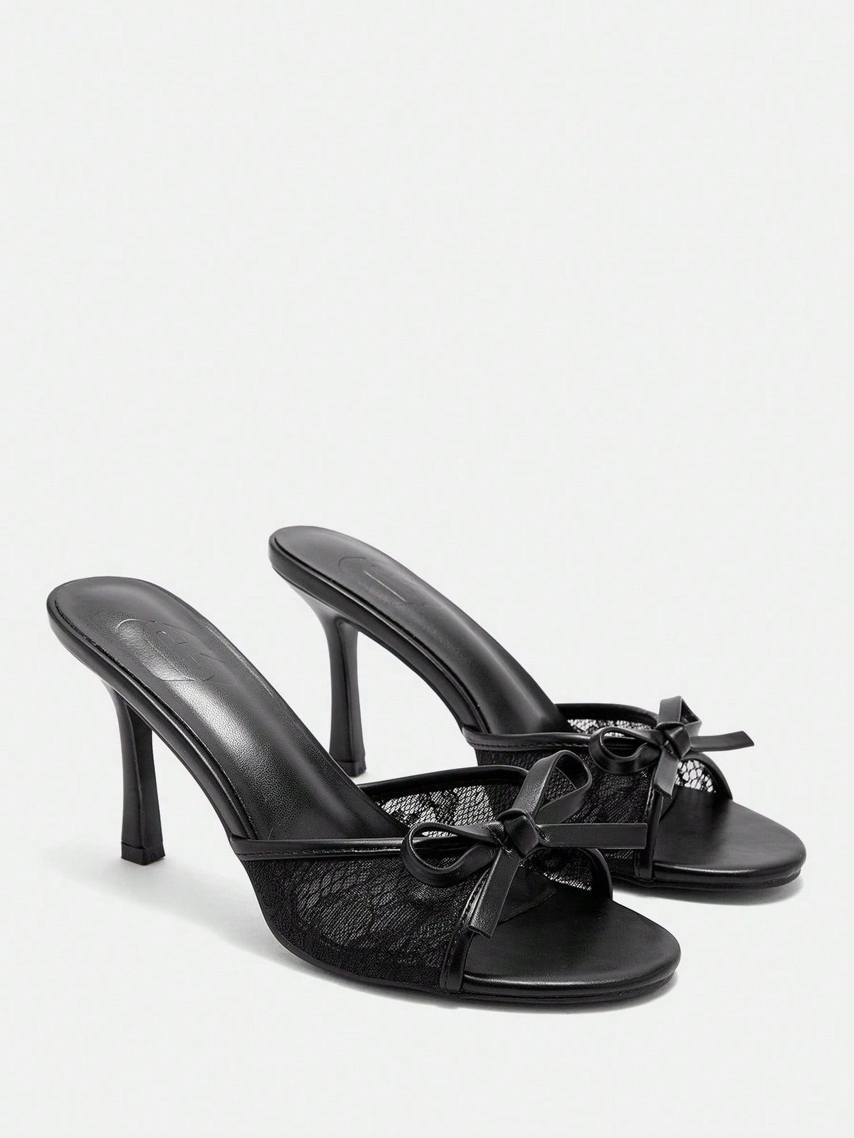 Women's black lace slip-on mule sandals featuring a high stiletto heel, open toe, and bow embellishment.