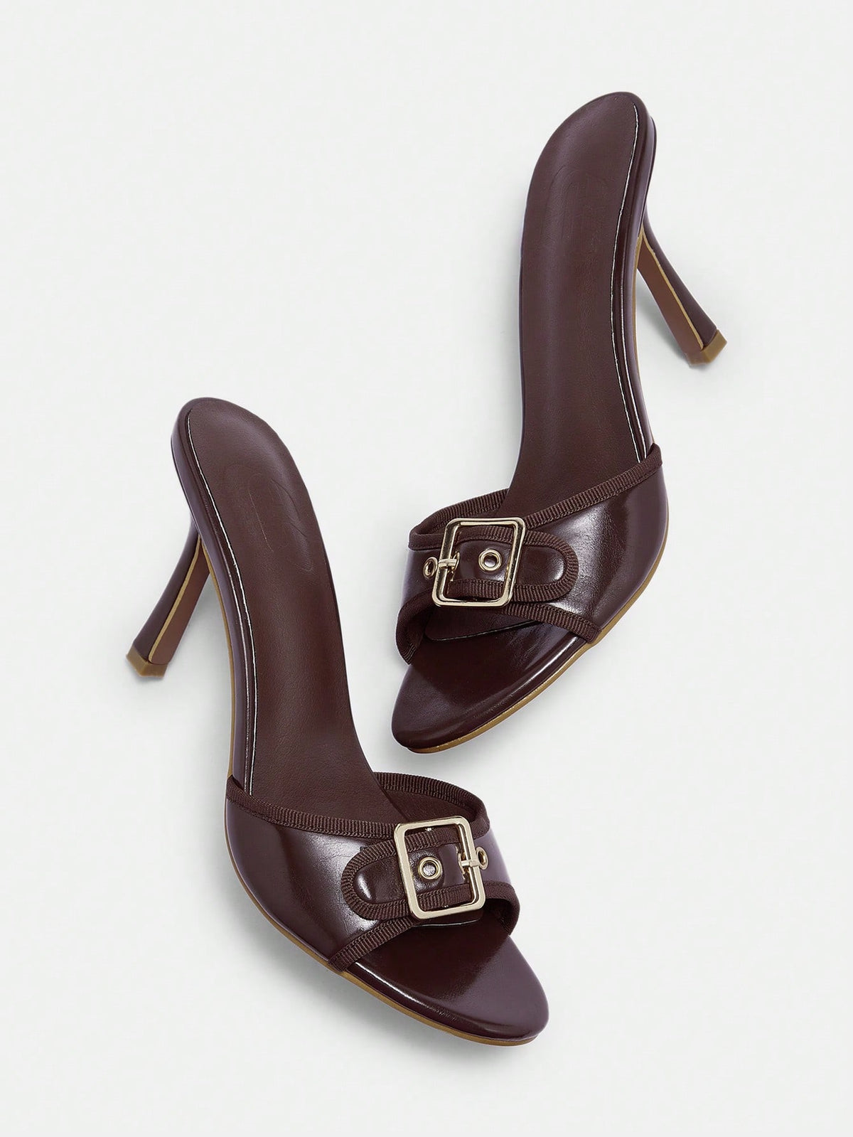 Women's brown leopard print high heel mule sandals with gold-tone buckle and grommet eyelet accents.