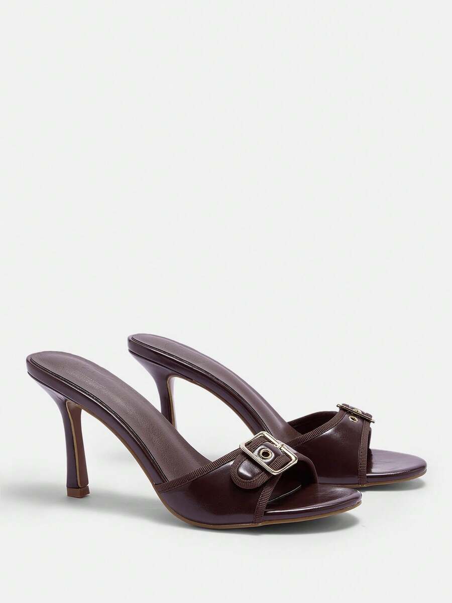 Women's brown leopard print high heel mule sandals with gold-tone buckle and grommet eyelet accents.