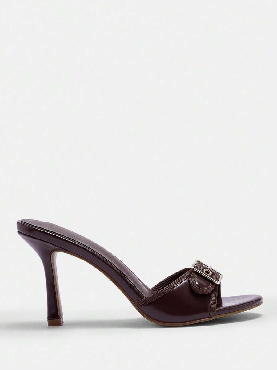 Women's brown leopard print high heel mule sandals with gold-tone buckle and grommet eyelet accents.