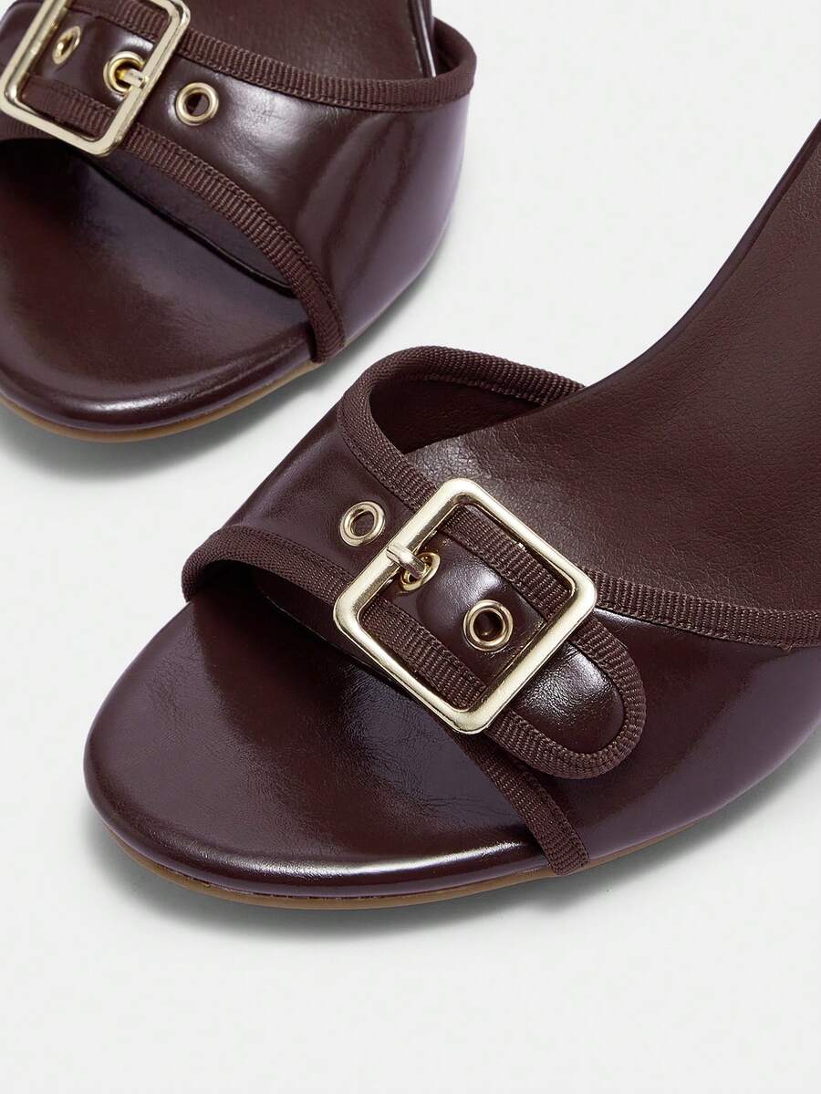 Women's brown leopard print high heel mule sandals with gold-tone buckle and grommet eyelet accents.
