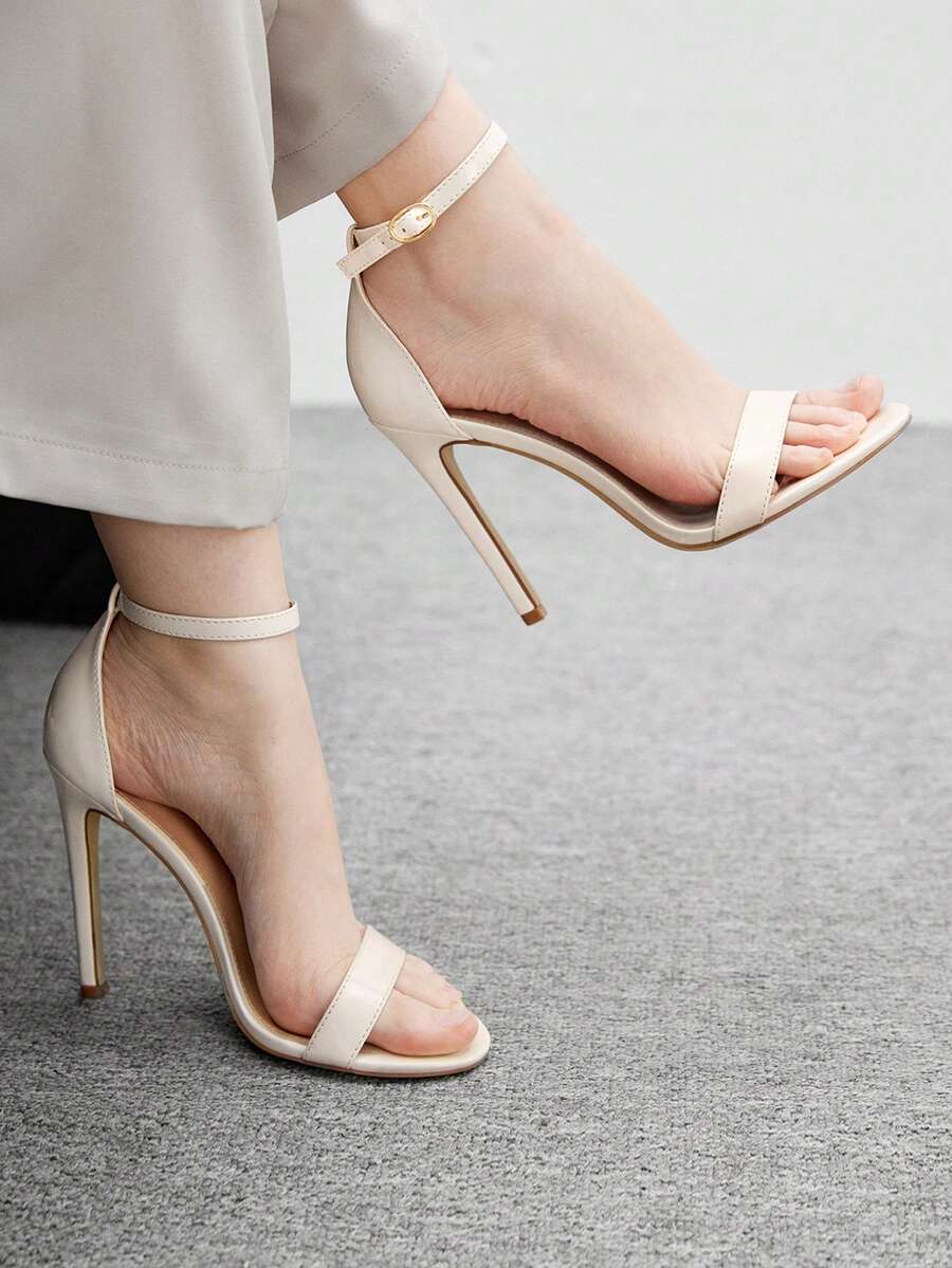 Women's stiletto sandals featuring an ankle strap buckle closure and classic round open toe design.