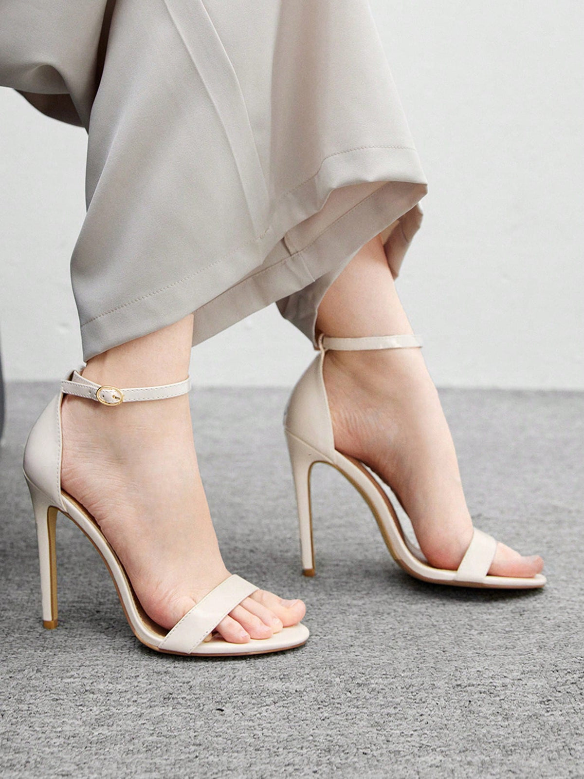 Women's stiletto sandals featuring an ankle strap buckle closure and classic round open toe design.