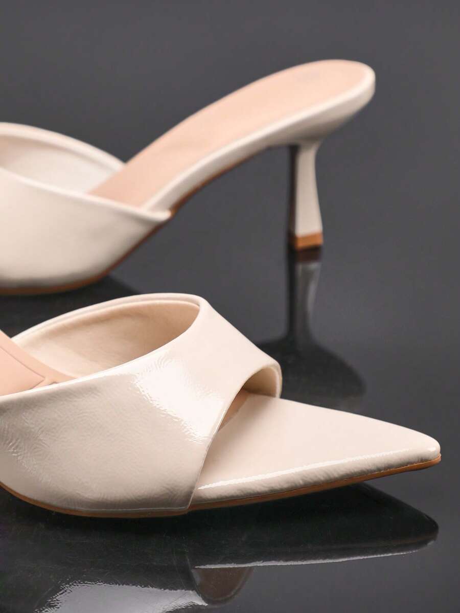 Black pointy toe kitten heel shoes for women featuring a sleek cut out mule design and glossy patent leather finish.