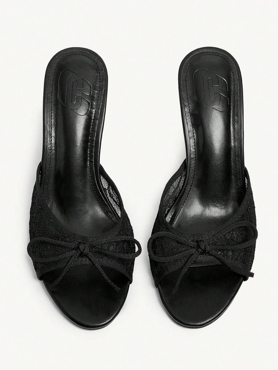 Open toe high heel slide sandals featuring lace details and a bow accent on the upper strap.