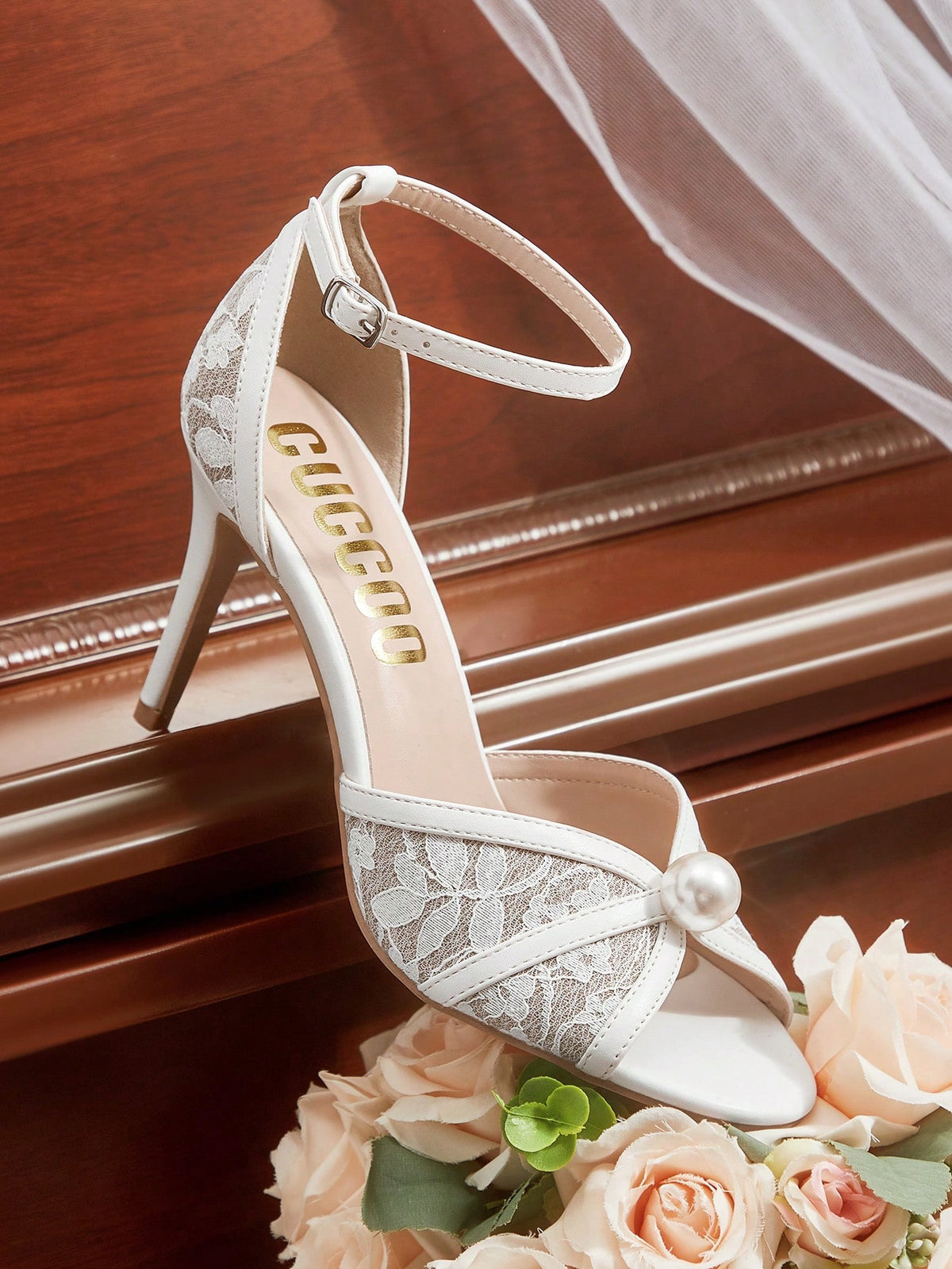 Beige high heel sandals with delicate lace overlay, pearl embellishments, stiletto heel, and adjustable ankle strap for bride and wedding party wear.