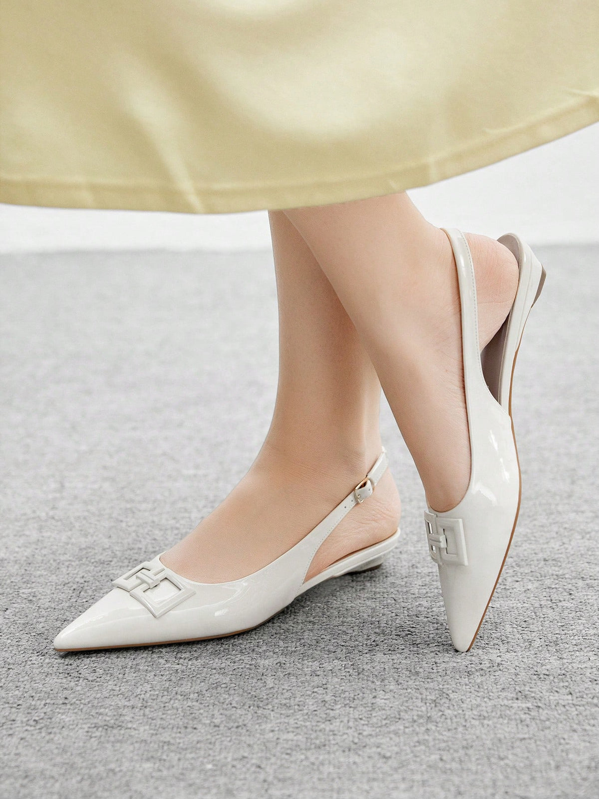 Women's pointed toe low wedge flat shoes crafted in PU leather with a slingback strap and stylish metal buckle detail.